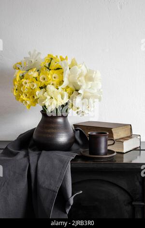 Studio shot di vaso con daffodils fiorente in piedi su un tavolo rustico Foto Stock