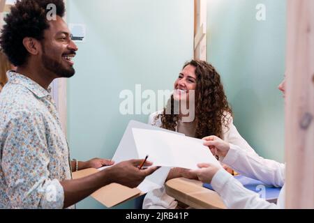 Uomo d'affari che consegna il documento a un collega in carica Foto Stock