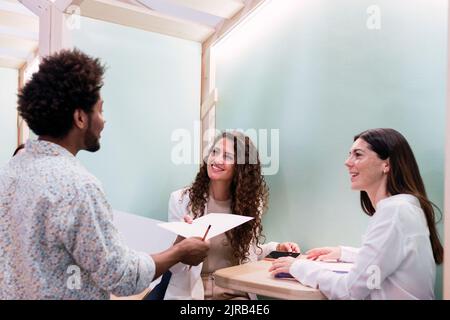 Uomo d'affari che consegna il documento a un collega in carica Foto Stock