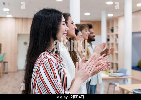 Il team aziendale stringe le mani dopo una presentazione in ufficio Foto Stock