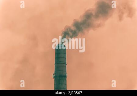 Fumo scuro come conseguenza di carbone che è bruciato in forni, che si sfugge da camini in una pianta di cemento in Byrnihat, Meghalaya, India. Foto Stock