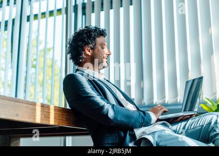 Uomo d affari con computer portatile lavoro in ufficio Foto Stock