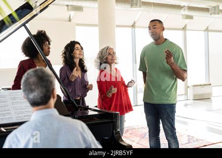 Uomo d'affari che canta i colleghi mentre si schianta le dita in ufficio Foto Stock