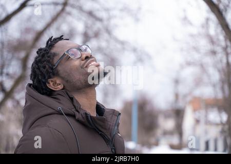 Uomo sorridente che indossa occhiali che guardano in alto Foto Stock