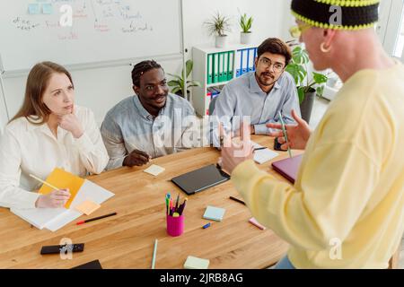 Imprenditore a discutere con i colleghi in ufficio Foto Stock