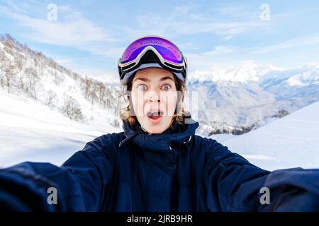 Donna scioccata con la bocca aperta davanti alle montagne innevate Foto Stock