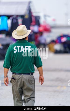 New Castle, DE, USA - 21 agosto 2022: Un membro dello staff di un grande mercato delle pulci all'aperto che opera all'alba al tramonto. Foto Stock