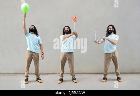 Immagine multipla dell'uomo bearded con gli oggetti davanti al muro Foto Stock