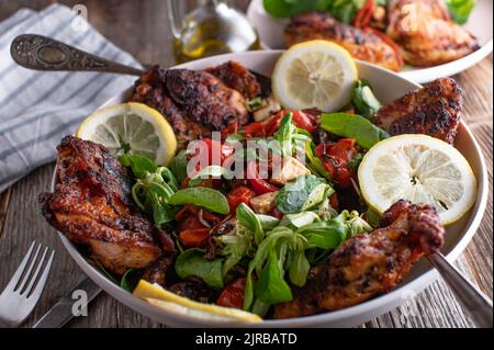 Pollo arrosto intagliato con insalata su sfondo tavolo di legno Foto Stock