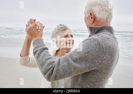 Felice coppia senior balli sulla spiaggia Foto Stock