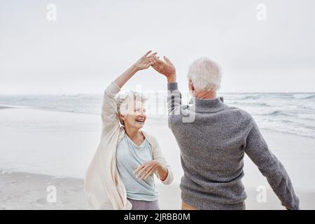 Felice coppia senior balli sulla spiaggia Foto Stock