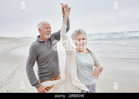 Felice coppia senior balli sulla spiaggia Foto Stock