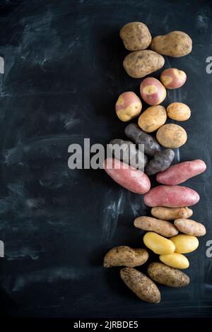 Studio shot di diverse varietà di patate piatto posato su sfondo nero Foto Stock