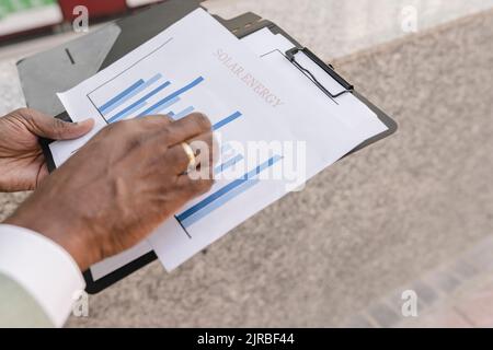 Mani di uomo d'affari che esamina il grafico Foto Stock