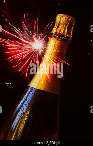 Bottiglia di champagne contro l'esplosione di fuochi d'artificio Foto Stock