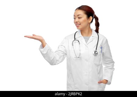 medico femminile asiatico che tiene qualcosa a portata di mano Foto Stock