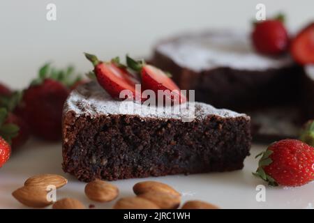 Fette di torta caprese. Torta al cioccolato e alle mandorle. Una torta squisita e senza farine al cioccolato dell'isola di Capri. Cosparso di zucchero in polvere. Scatto A. Foto Stock