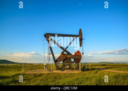 Un Lufkin Mark II advanced-geometria martinetto della pompa di pompaggio di olio grezzo da una produzione di olio e ai piedi delle colline di southern Alberta Foto Stock