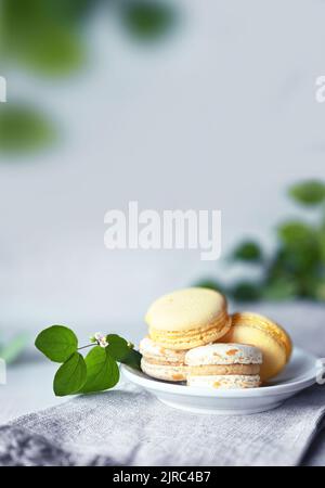 Amaretti. Amaretti gialli con foglie verdi. Deliziosi dessert francesi. Maccheroni sul tavolo. Foto Stock