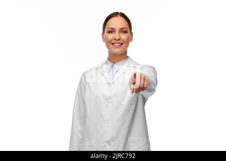 felice medico femminile che indica alla macchina fotografica Foto Stock