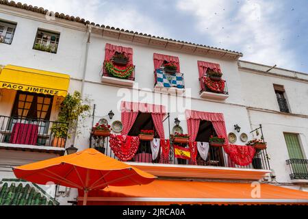 Una vista esterna di un edificio residenziale con finestre decorate a Malaga, Spagna Foto Stock