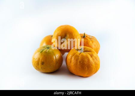 Superficie ricoperta da cinque tangerini freschi e succosi maturi, composizione isolata su fondo bianco. Foto Stock