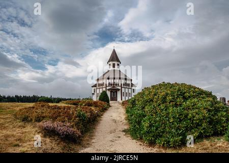 Piccola cappella bianca rurale Tesarovska con cimitero nel villaggio di Korenov, Jizera montagne, Repubblica Ceca. Paesaggio estivo, stormy Sky.Wooden histori Foto Stock