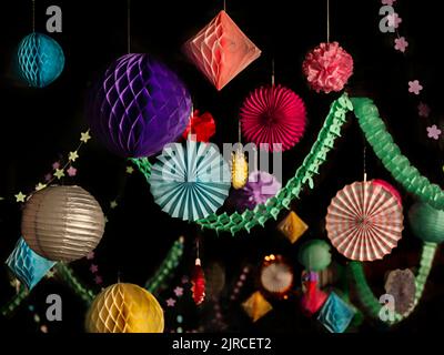 Colorato natale o festa lanterna di carta, stelle, palline decorazioni su sfondo nero Foto Stock