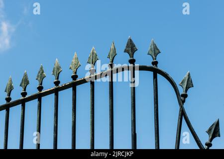 La recinzione in ferro forgiato con frecce su sfondo blu cielo a Lisbona, Portogallo Foto Stock