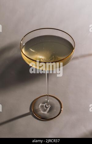 Spumante Champagne in alto bicchiere coupé dorato con gambo sottile Foto Stock