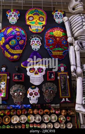 muro con souvenir per i turisti e ornamenti appesi di tradizionali catrinas, teschi e scheletri per halloween e giorno dei morti in messico Foto Stock
