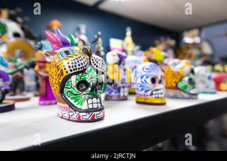 Scultura in ceramica statua di un giorno tradizionale del cranio guerriero azteco messicano morto con un cappello in un negozio di souvenir a Puebla, Messico Foto Stock