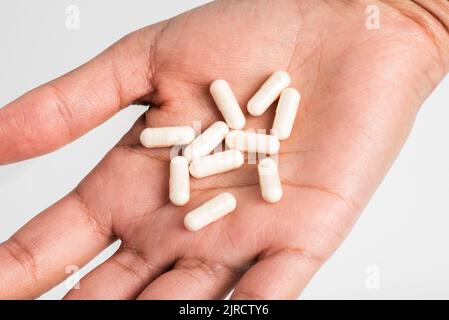 Mano che tiene pillole di vitamina, supplementi nel palmo della mano Foto Stock