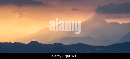 Splendide silhouette di una montagna al colorato tramonto d'estate Foto Stock