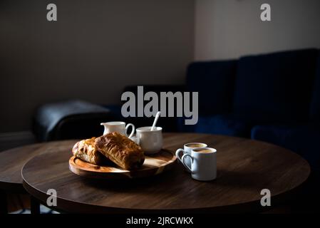 Pasticcini e caffè sul tavolino nel soggiorno Foto Stock