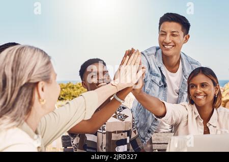 Fiducia, comunità e collaborazione con i cinque più alti da parte dei colleghi di lavoro che si divertono a costruire il team, divertendosi insieme all'aria aperta. Diversi gruppi si uniscono in goal Foto Stock