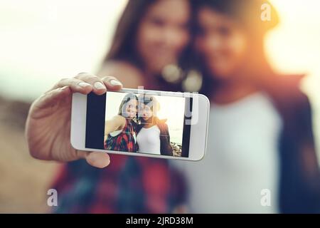 La nostra estate insieme è un ricordo che durerà per sempre. Due giovani amici che prendono un selfie insieme all'aperto. Foto Stock