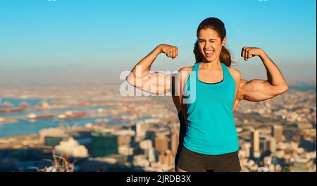 Mostrando le sue pistole. Ritratto corto di una giovane donna in piedi di fronte al suo ragazzo che flette i muscoli. Foto Stock