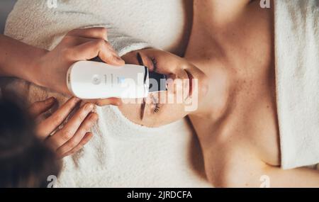 Vista dall'alto donna che riceve la pulizia ultrasonica del naso. Pulizia pori, acne. Procedure di cosmetologia. Dermatologia, cosmetologia. Bellezza del viso Foto Stock