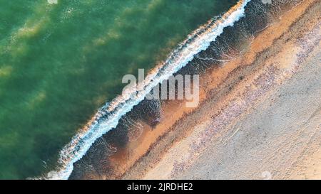 Onde sulla spiaggia vista dall'alto, fuco di costa e sabbia Foto Stock