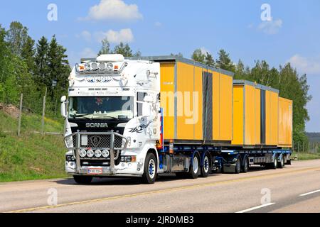 Il camion bianco personalizzato Scania Lahma-Trans Oy trasporta cabine portatili come trasporto di carichi larghi sull'autostrada 9 in estate. Orivesi, Finlandia. Giugno 6, 2019. Foto Stock