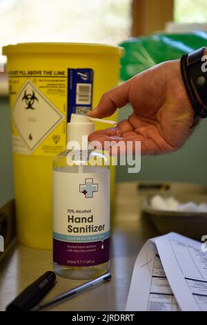 Membro del team medico che utilizza disinfettante per le mani durante l'implementazione del vaccino COVID-19, Bordon, Hampshire, Regno Unito. Foto Stock