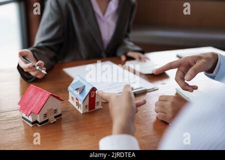 Giovane coppia a decidere prima di acquistare e firmare il contratto. Concetto di bene immobile Foto Stock