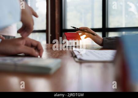 Giovane coppia a decidere prima di acquistare e firmare il contratto. Concetto di bene immobile Foto Stock