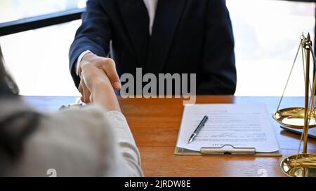 Un avvocato di affari nell'incontro con il suo cliente nell'ufficio di uno studio legale. Agitare le mani per un accordo di successo. Immagine ravvicinata Foto Stock