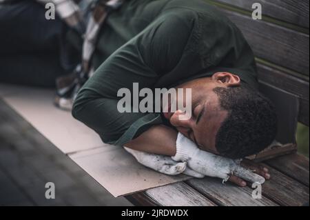 Uomo afroamericano che dorme sulla panca Foto Stock