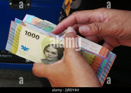 Giacarta, Giacarta, Indonesia. 23rd ago, 2022. I residenti in coda per cambiare le nuove banconote da 2022 rupiah al Senen Market, Jakarta, il 24 agosto 2022. Bank Indonesia (BI) ha appena lanciato le nuove banconote da 2022 rupiah in concomitanza con la Giornata dell'indipendenza indonesiana del 77th, Bank Indonesia e il governo ne hanno varate 7, costituite da IDR 100.000, IDR 50.000, IDR 20.000, IDR 10.000, IDR 5.000, IDR 2.000 e IDR 1.000 denominal, Bank Indonesia (BI) assicura che il denaro sia disponibile presso i bancomat bancari convenzionali. Queste sette nuove denominazioni di rupia sono ufficialmente valide, emesse e circolate come l Foto Stock