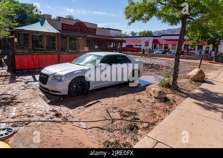 Il parcheggio fangoso di una taverna lungo Mill Creek, che ha inondato la notte prima a Moab, Utah. Foto Stock