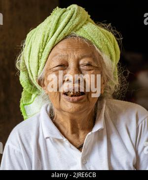 La vecchia donna con denti neri guarda la macchina fotografica. Foto Stock