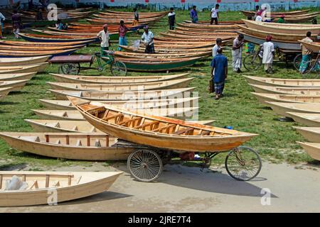 Manikganj, Dhaka, Bangladesh. 24th ago, 2022. Centinaia di barche di legno artigianali sono in vendita presso il più grande mercato nautico del Bangladesh a Manikgonj, Bangladesh. Utilizzato dalla gente del posto durante il monsone, quando forti precipitazioni causano lo scoppio della riva del fiume, ogni nave costa tra Â£ 30 e Â£ 80 a seconda delle loro dimensioni e della qualità dei materiali utilizzati per costruirli. La gente si è affollato al mercato all'aperto per comprare le barche in un'offerta per prepararsi per la stagione piovosa imminente. Credit: ZUMA Press, Inc./Alamy Live News Foto Stock